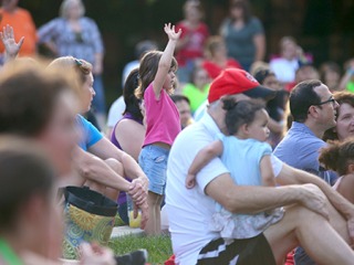 A crowd of families sitting on a lawn
