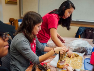 Two students make bird feeders out of pinecones