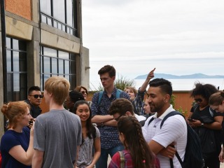 A group of students standing on a terrace by the ocean