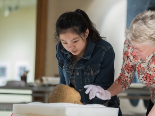 Monessa Cummins, associate professor of classics, and Jiayun Chen ’19, a classics and art history double major, examine a marble Roman portrait head, believed to be from the 1st century, in the print study room of the Burling Library.