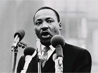Martin Luther King, Jr. speaking behind several microphones
