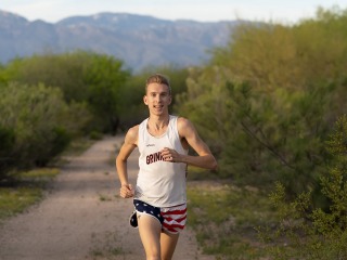 Adam Dalton ’16 running on a remote road in the mountains wearing Grinnell shirt