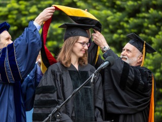 Kristin DeMoss receiving regalia in honorary degree ceremony