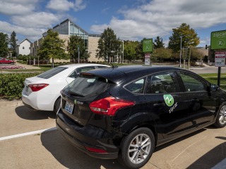 Two zipcars parked in lot across from Chrystal Center