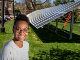 Avery Barnett in front of solar panels