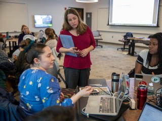 Professor Tammy Nyden (center) listens to two students during class