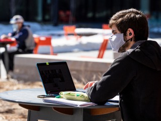 students studying at outside tables