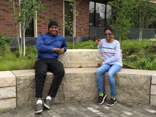 Erick Leggans and Ariel Richards ’23 sit on limestone benches outside the Humanities and Social Studies Center. 