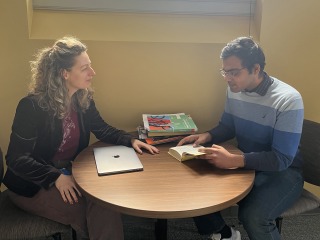 A man and a woman collaborate on work at a table