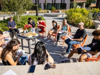 Professor Todd Armstrong sitting with class in the Outdoor Learning space