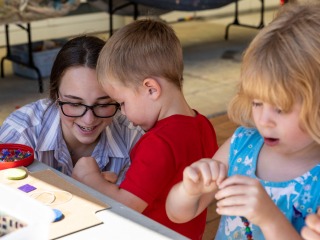 two little kids working on a craft project with teacher