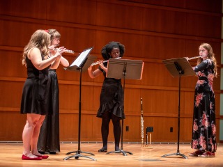 Four flautists perform onstage