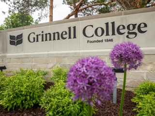 Grinnell College gateway sign with purple flowers