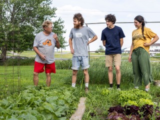 four people standing in garden