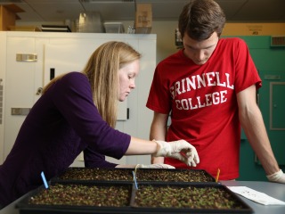 Two students in a biology lab, one of who is wearing a Grinnell College t-shirt