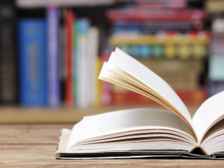open book on wood table with book in the background
