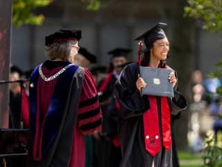 Woman receiving diploma from President Anne F. Harris at the 2023 Commencement Ceremony. P