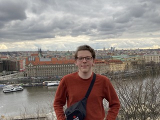 I stand proudly in Prague, next to a river.