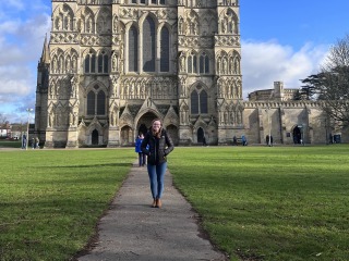 Amy Rinehard stands on the pathway to an ornate cathedral