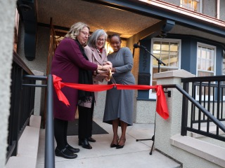 Rachel Bly ’93, left, President Anne F. Harris, and Bernadine Douglas cut the ribbon during the Hannah Alumni House dedication Thursday.