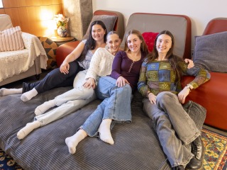 Four smiling young women on a giant beanbag chair
