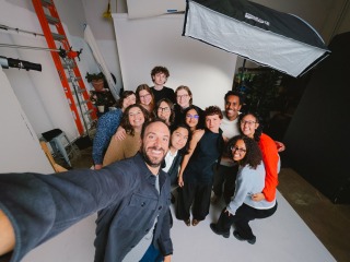A group of Grinnell students poses for a selfie with a professional photographer