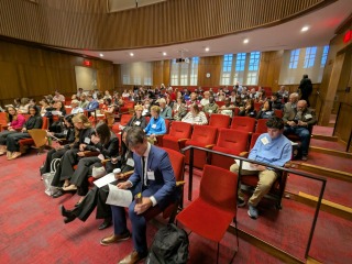 Participants in the Iowa Human Rights Research Conference are seated in an auditorium