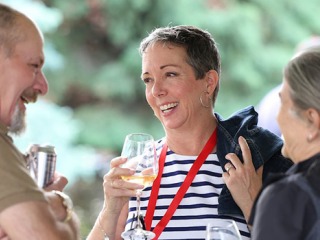 Reunion attendees hold beverages and laugh with each other 