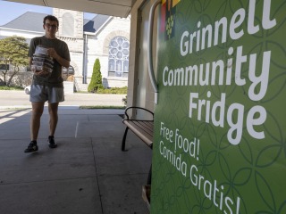 student walking with food in hand to stock fridge