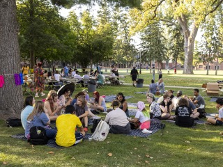 Students enjoying a picnic at the Stonewall Resource Center (SRC) welcome event.