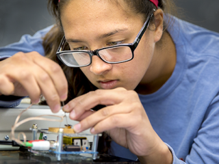 A student works with circuitry in a Grinnell Science Project lab