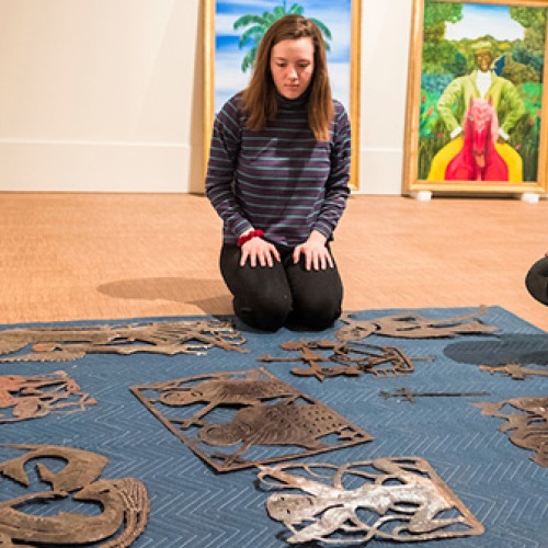 Students lay out art pieces for exhibit