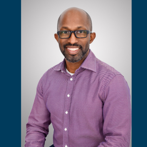 Dr. Willis in purple shirt sitting for photo 