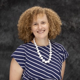 Curly Blond Hair Fair skinned woman smiling. 