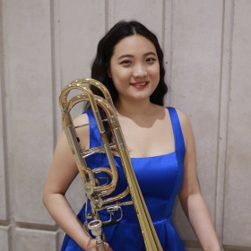 Iris Xiaoyu Liu holding a trombone