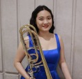 Iris Xiaoyu Liu holding a trombone