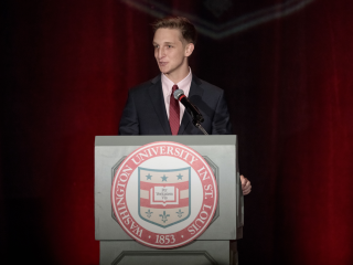 A young man speaks at a podium
