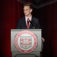 A young man speaks at a podium