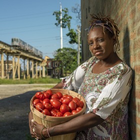 LaDonna Redmond holds a bushel of tomatoes
