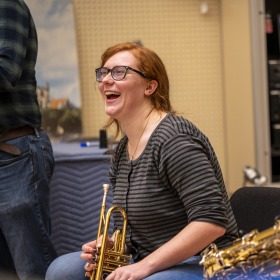 Student smiling during jazz ensemble rehearsal 