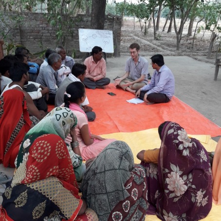 Anthony Wenndt sitting with farmers in India