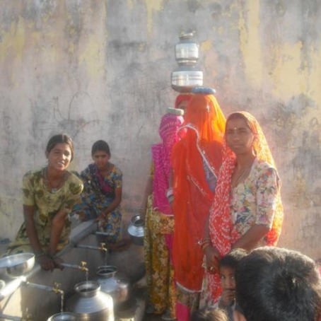 Indian women filling water jugs