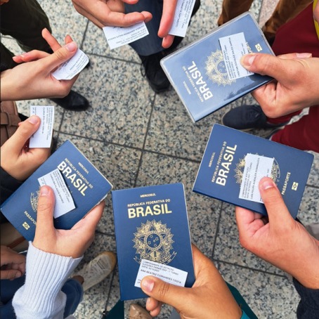 hands holding Brasil passports and ids