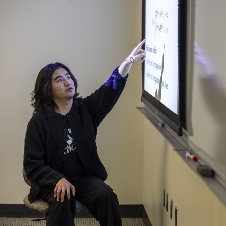 Evan Shen ’27 pointing to research findings on a screen