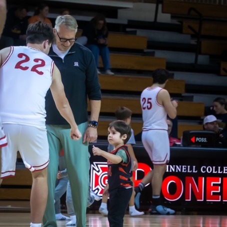 little boy giving fist pump to basketball player on the court