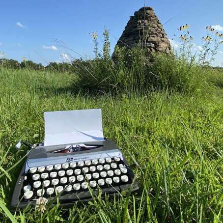 Old manual typewriter sitting in the prairie grass