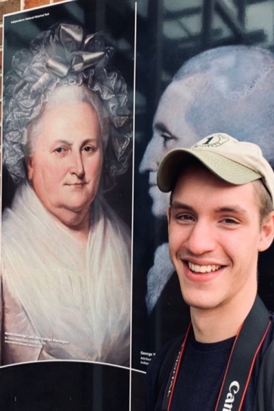 Jack Thornton smiles in front of a mural