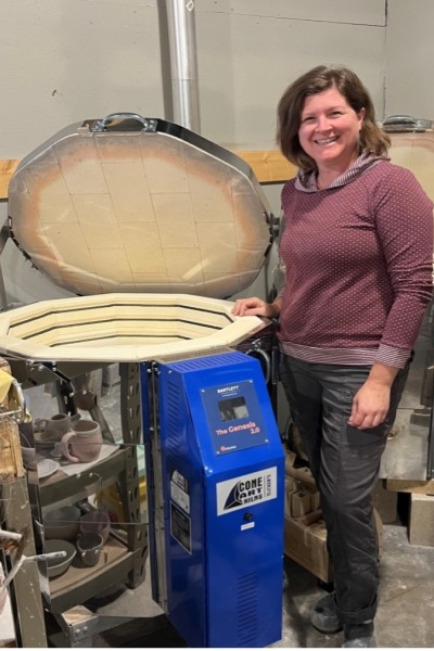 Jess Lease stands next to the new kiln