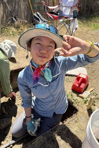 Avajane Lei '28 with a Chinese brown glazed stoneware fragment she uncovered on site.