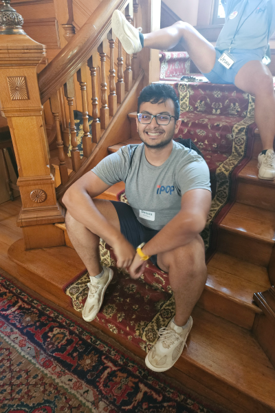 Parikshit sits on an ornate carved wooden staircase with thick rugs